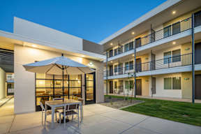 A patio with a table and chairs is set up outside a building.