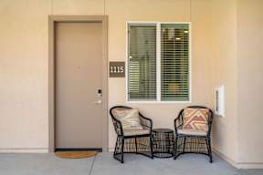 Two chairs with pillows are placed on a patio.