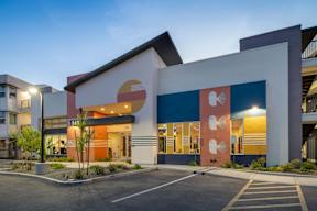 A modern building with a parking lot in front.