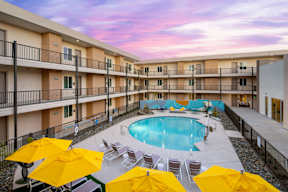 A pool surrounded by yellow umbrellas and chairs.