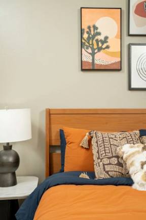 A bed with a blue pillow and a dog on it.