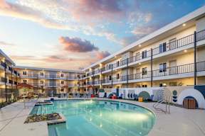 A large swimming pool in the middle of a courtyard surrounded by apartment buildings.