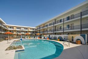 A large swimming pool in front of apartment buildings.