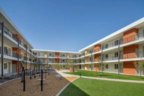 A sunny day at a modern apartment complex with a playground.