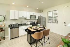 A modern kitchen with a dining table set for two.