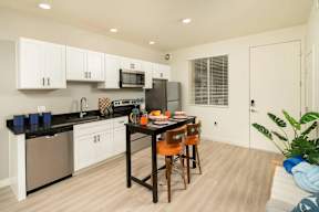 A kitchen with white cabinets and a black countertop.