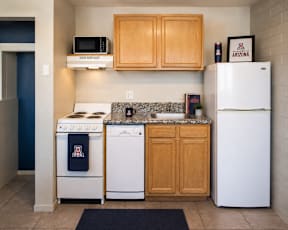A kitchen with a white refrigerator, a white stove, a white dishwasher, and a white microwave.