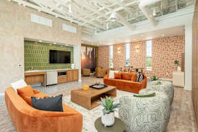 A living room with orange and green furniture and a flat screen TV.