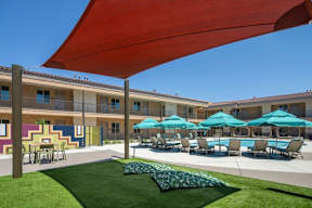A large red shade structure is over a pool area.