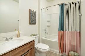 A bathroom with a toilet, sink, and shower.
