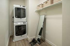 A white microwave oven is on the floor next to a mirror.