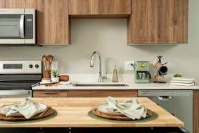 A kitchen with a wooden countertop and a stainless steel oven.