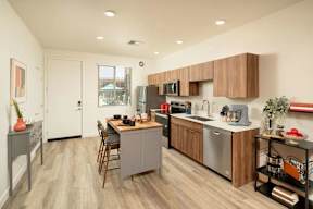 A modern kitchen with wooden cabinets and a grey island.