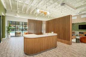 A reception area with a wooden reception desk and a white ceiling.