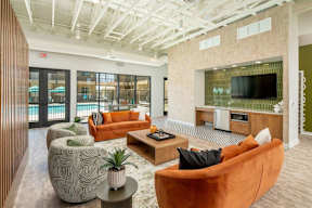 A modern living room with a flat screen TV and a glass door leading to a balcony.