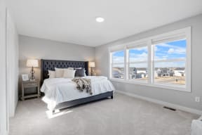 a bedroom with a large window and a bed