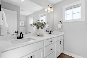 a white bathroom with two sinks and a mirror