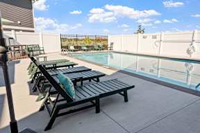 A pool with a bench and a pillow on it.