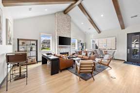 A modern living room with a stone fireplace and wooden floors.
