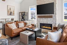 A living room with a fireplace and a flat screen TV mounted on the wall.