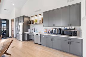 A modern kitchen with a refrigerator, microwave, and oven.