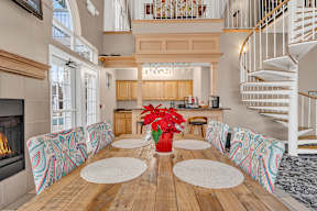A large open plan living space with a wooden floor and a spiral staircase.