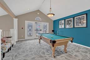 A pool table in a room with a carpeted floor.
