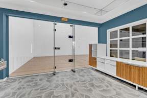 A room with a blue wall and a white cabinet.