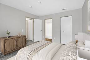 A bedroom with a bed, dresser, and mirror.