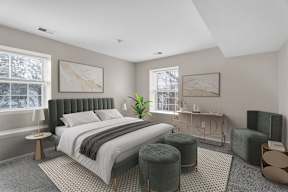 A bedroom with a large bed and a green chair.
