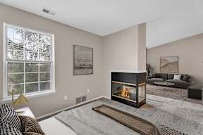 A modern living room with a fireplace and a large window.