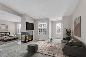 A modern living room with a fireplace and a grey couch.