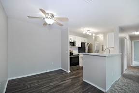A kitchen with a white island and a ceiling fan.