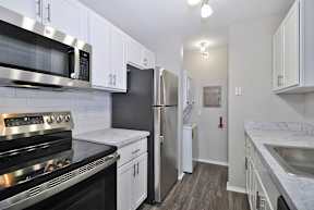 A kitchen with white cabinets and stainless steel appliances.