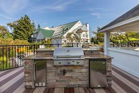a stone outdoor grill with stainless steel appliances on a patio