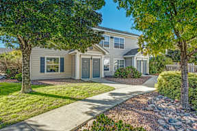 A house with a grey roof and a white fence.