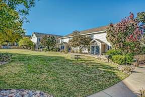 A house with a lawn and trees in front.