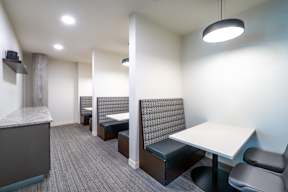 a communal area with tables and chairs and a kitchen