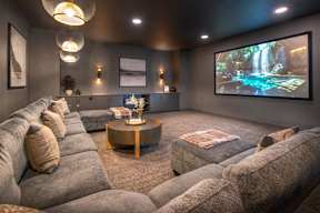a large screening room with couches and a large screen tv