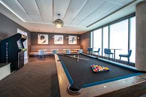 a game room with a pool table and a large window