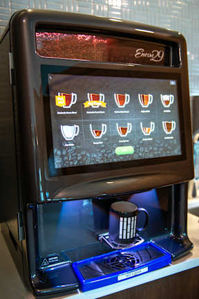 a coffee maker with a coffee cup in front of it
