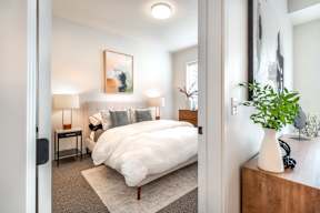 a bedroom with a bed and a vase with a plant
