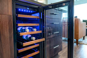 a wine refrigerator with bottles in it in a living room