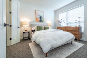 a bedroom with a bed and a dresser and a window