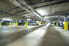 a parking garage with cars and yellow columns