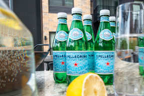 a group of bottles of sparking water and a lemon on a counter