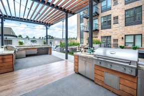 a large outdoor kitchen with stainless steel appliances and a pergola