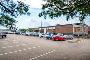 a parking lot full of cars in front of a building