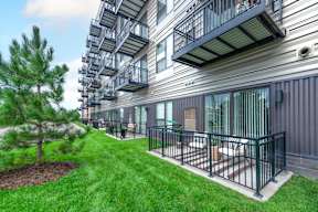 the private balconies of an apartment building with grass and trees