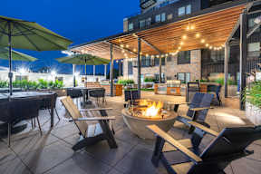 a patio with tables and chairs and a fire pit